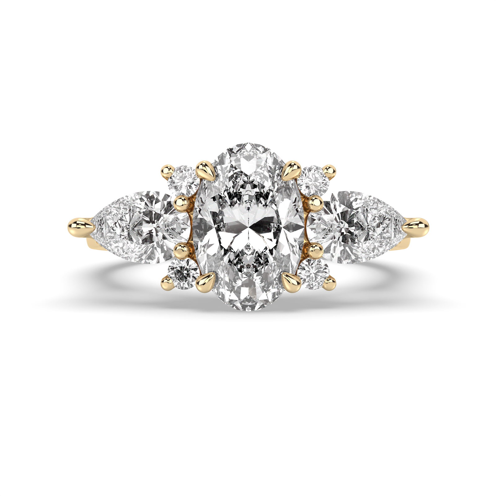 A yellow gold three-stone diamond ring featuring a large oval center diamond flanked by two smaller round diamonds, with pear-cut side diamonds, set against a clean white background.
