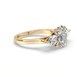 A yellow gold ring featuring a cluster of three round brilliant-cut diamonds, shown on a clean white background with a soft shadow.