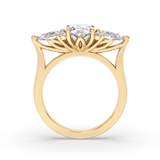 A yellow gold ring with a decorative floral crown setting featuring oval, pear and round diamonds, shown on a plain white background.