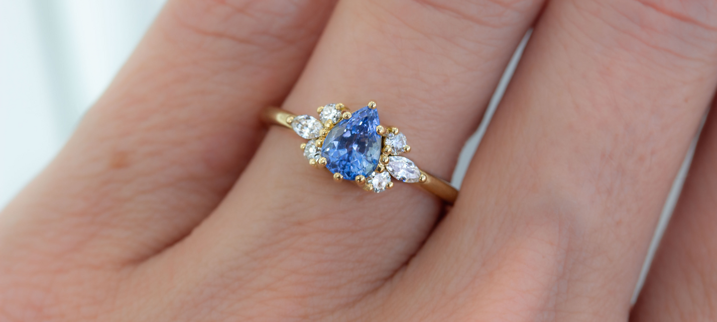 Sapphire and Diamond Cluster engagment ring in 18K Yellow gold worn on the hand